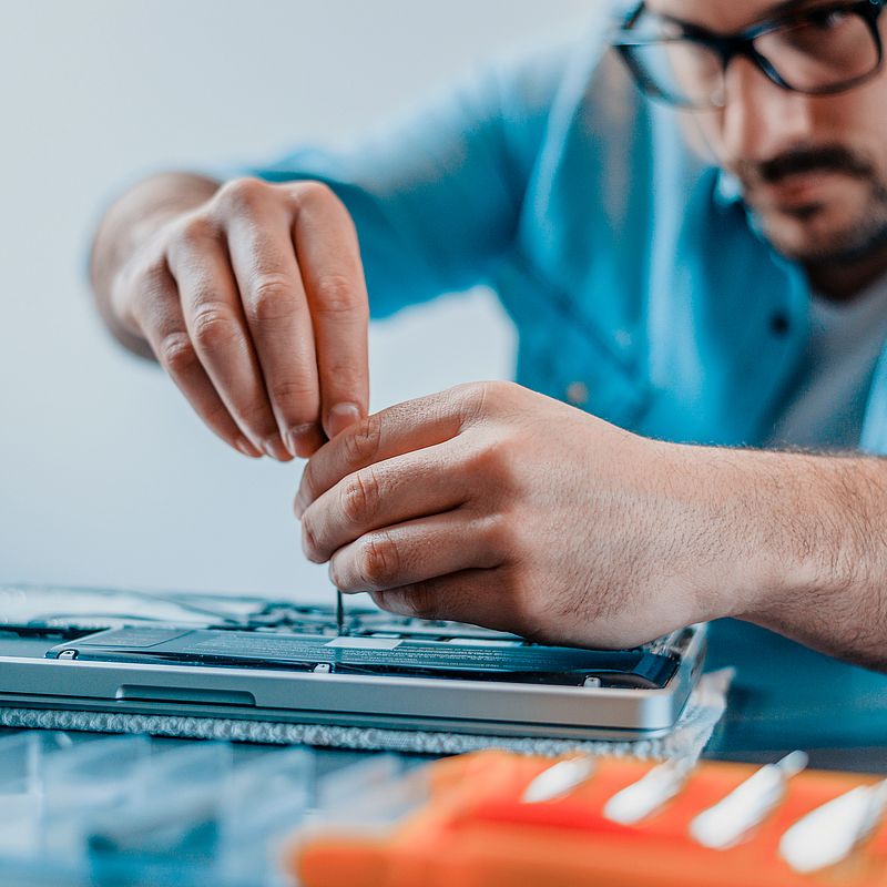 Engineer repairs laptop with screwdriver.Close-up.