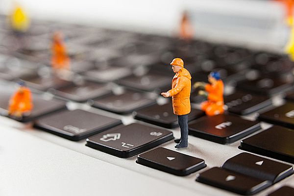 miniature-workmen-repairing-laptop-keyboard